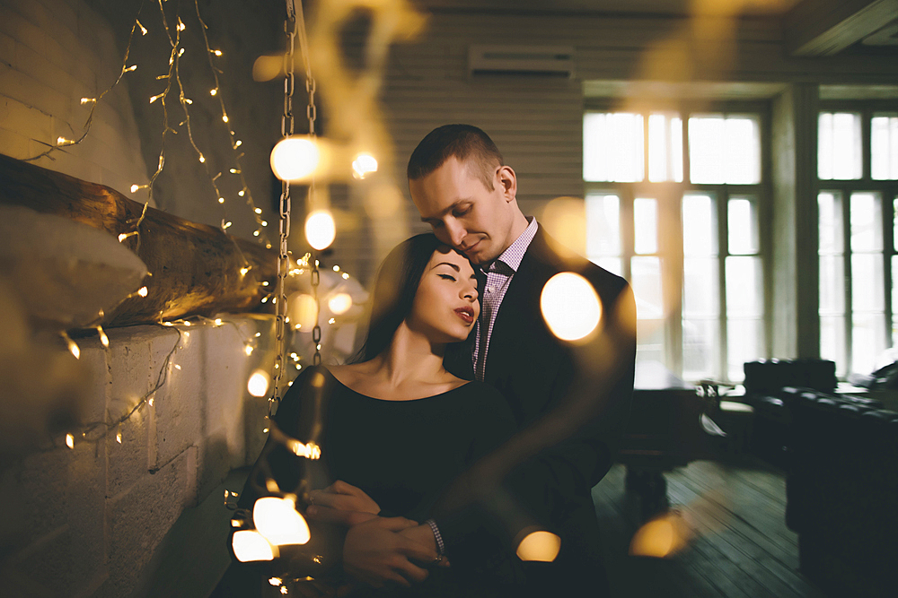 Caucasian couple hugging near wall