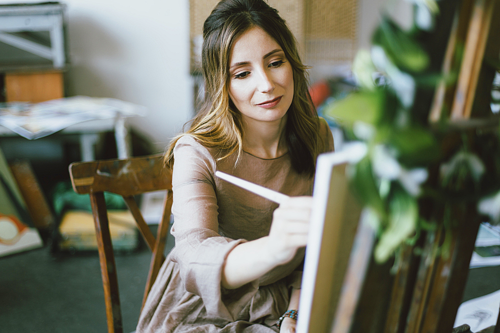 Caucasian woman painting on canvas