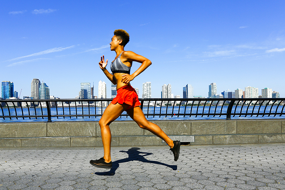 Mixed race woman running at waterfront