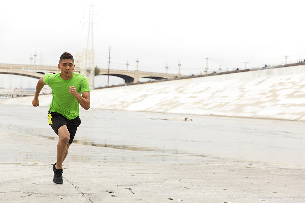 Mixed Race man running in canal