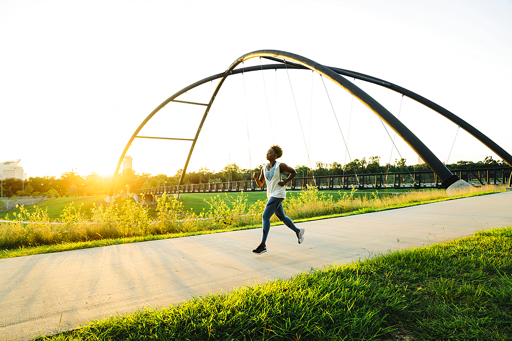 Mixed race woman running on path in park