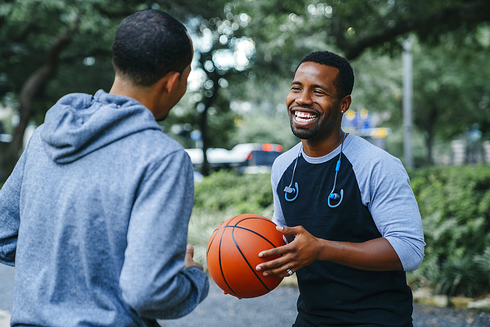 Smiling Black men playing basketball