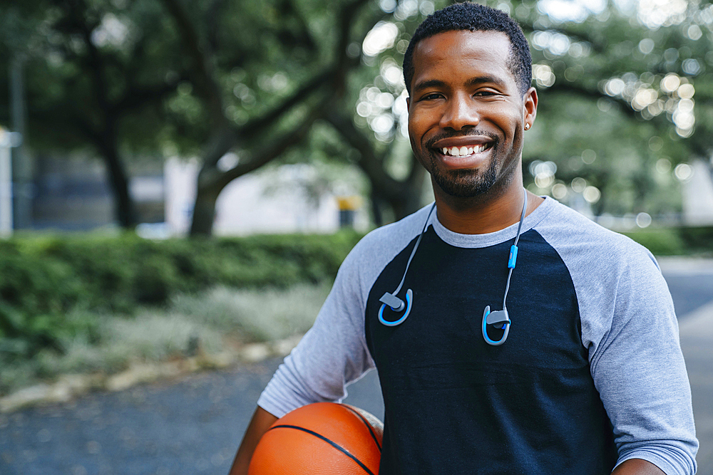 Portrait of smiling Black man holding basketball