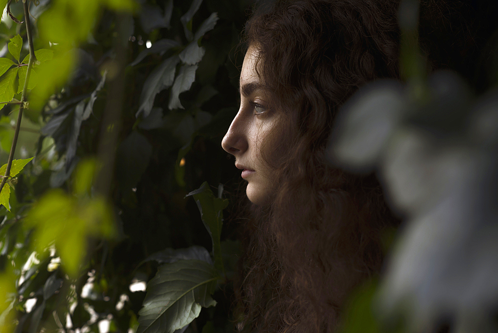 Profile of serious Caucasian woman in leaves