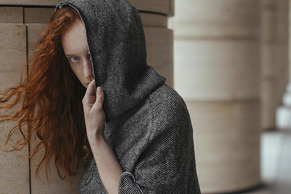 Caucasian woman hiding face behind hood