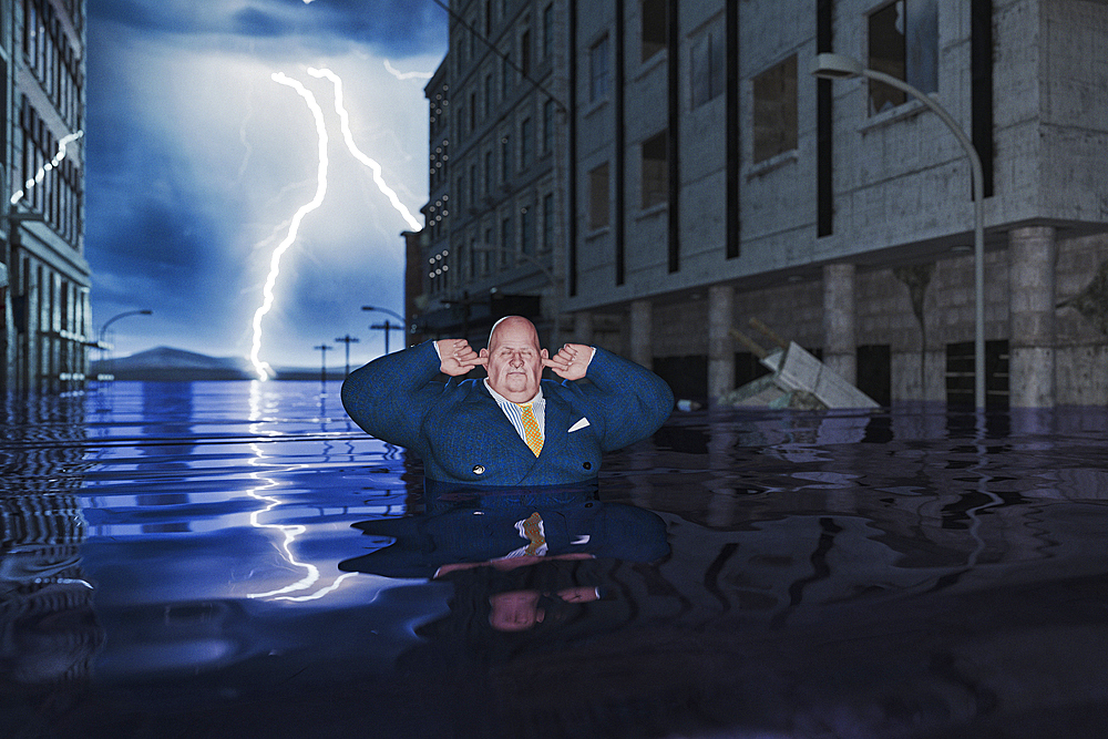 Overweight businessman with fingers in ears in flooded city