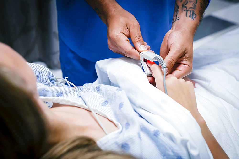 Nurse placing finger monitor on patient