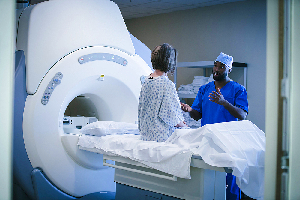 Technician talking to patient at scanner