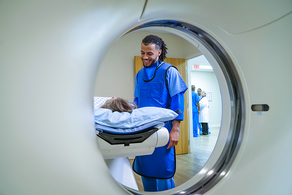 Technician talking to patient near scanner