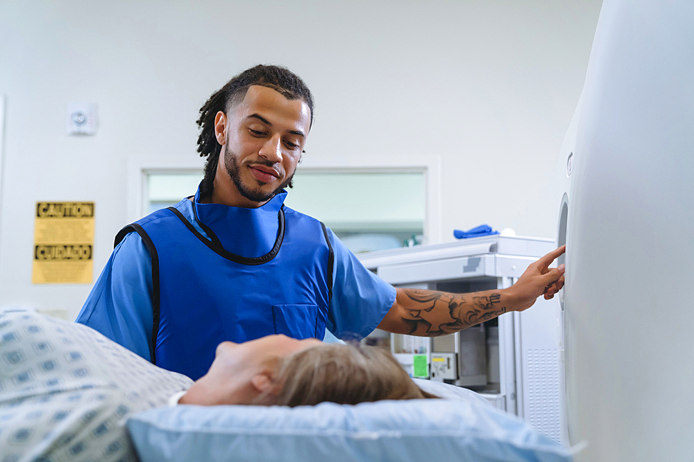 Technician talking to patient near scanner