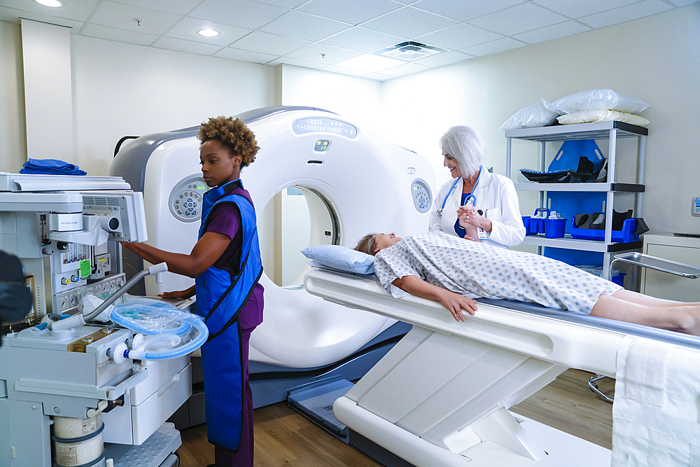 Technician preparing scanner for doctor comforting patient