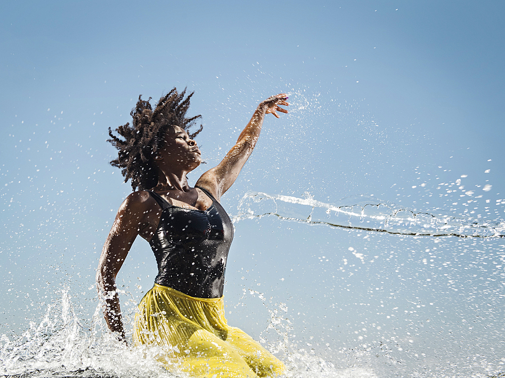 Water spraying on black woman dancing