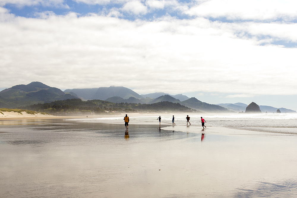 Distant people running on beach