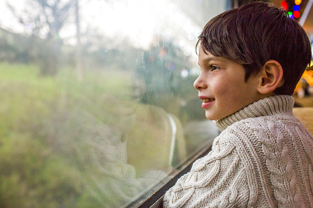 Mixed Race boy looking out train window