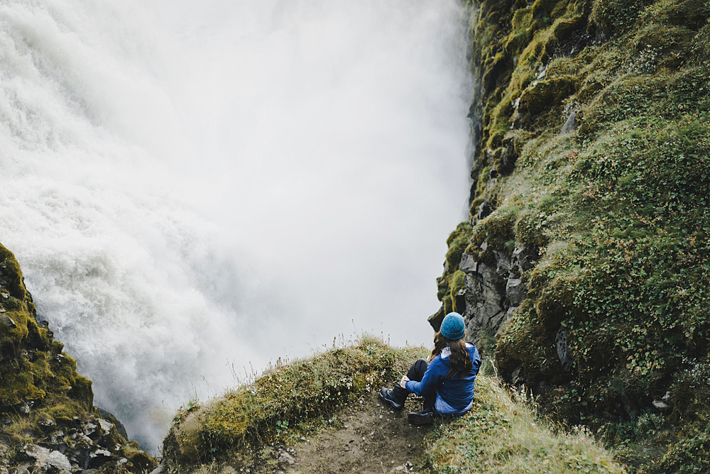 Caucasian woman watching waterfall