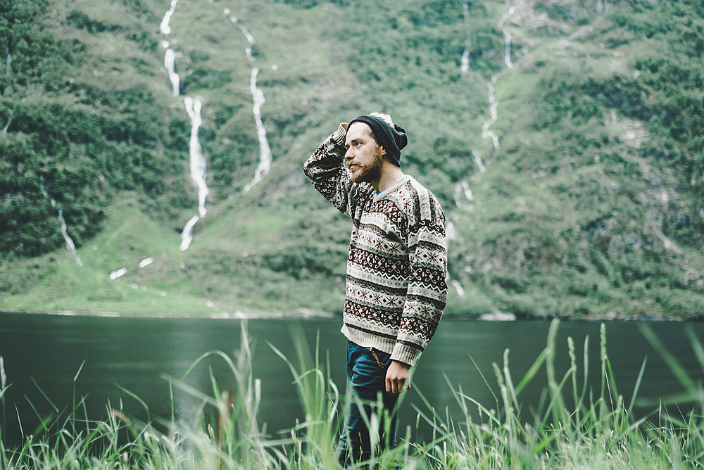 Pensive Caucasian man standing near river