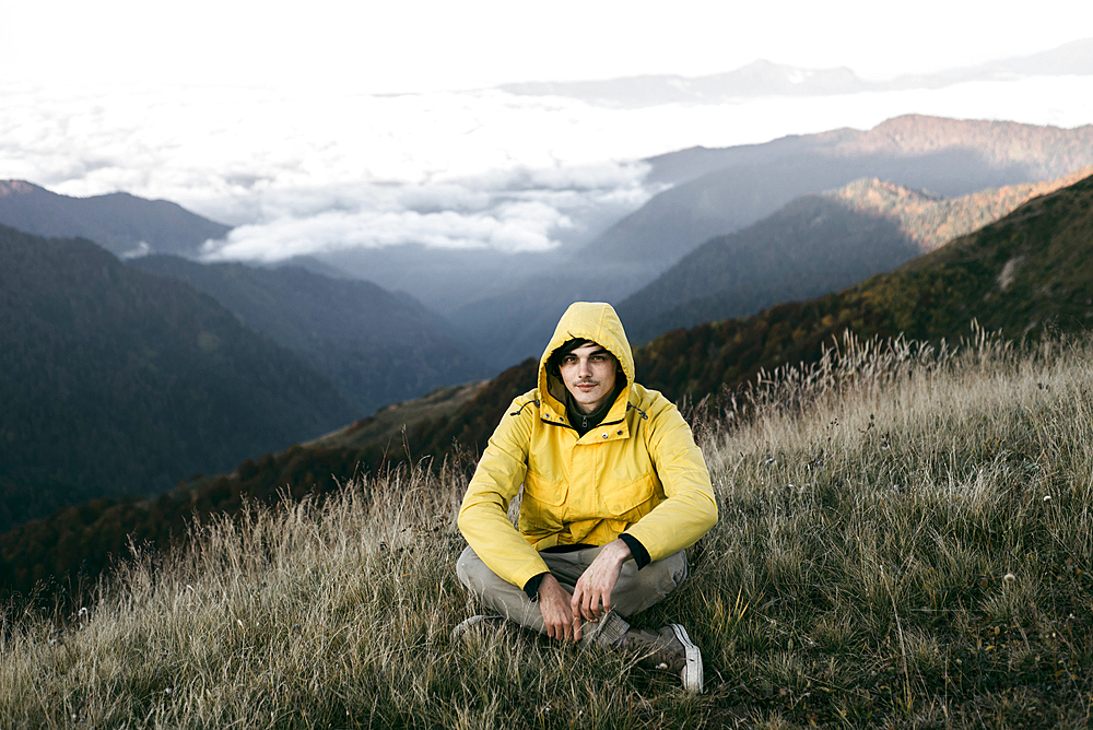 Caucasian man sitting in remote mountain landscape