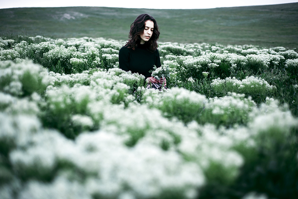 Caucasian woman standing in the field of wildflowers