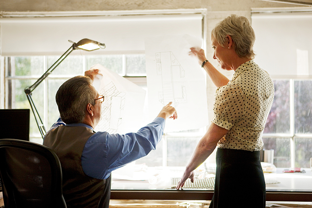 Architects examining blueprint in office