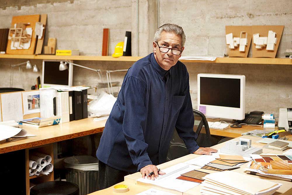 Portrait of serious Hispanic designer examining color swatches in office