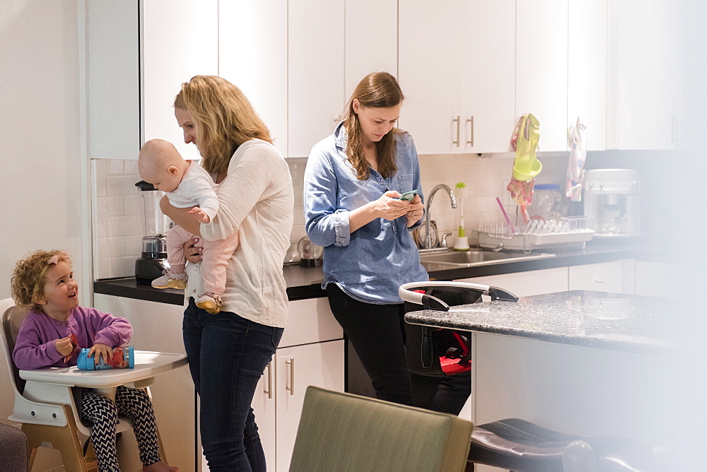 Caucasian mothers and daughters in kitchen