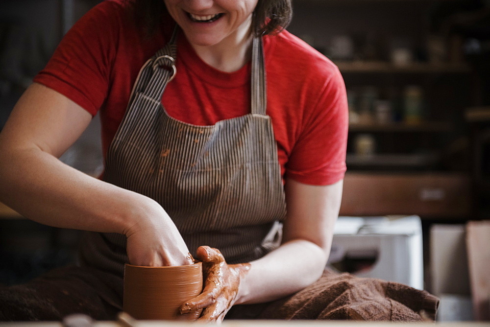 Caucasian woman shaping pottery clay