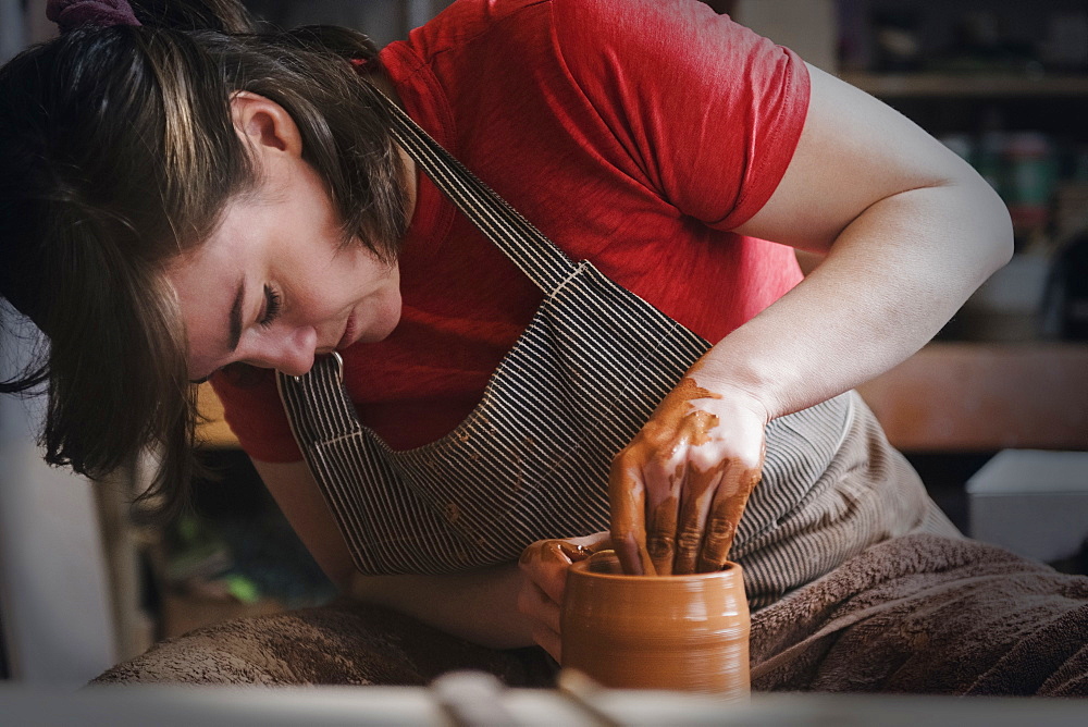 Caucasian woman shaping pottery clay