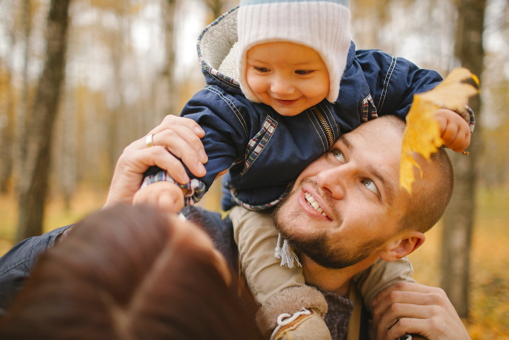 Middle Eastern father carrying baby son in autumn