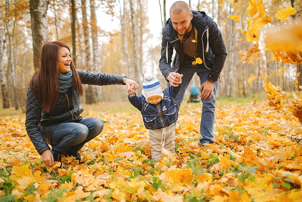 Middle Eastern parents walking with baby son in autumn