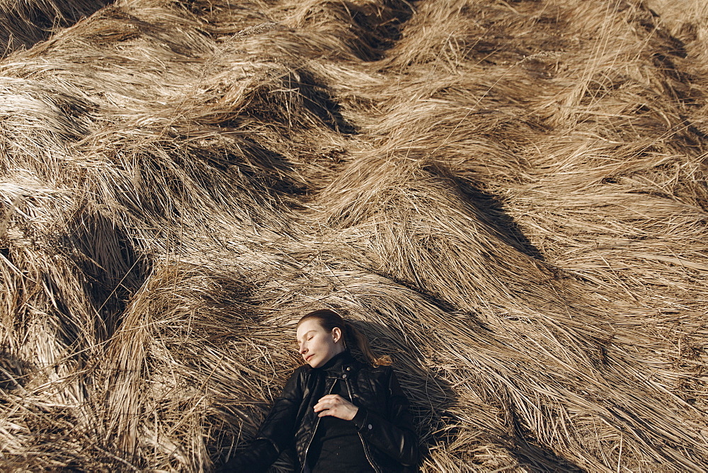 Middle Eastern woman resting in tall grass