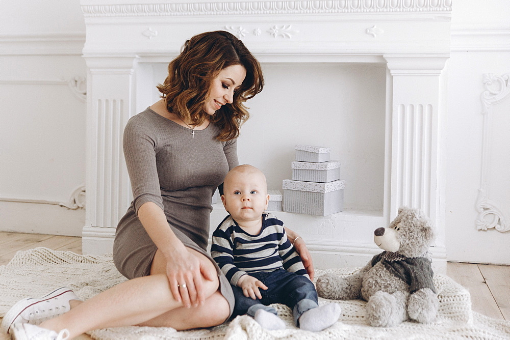 Caucasian mother sitting on floor with baby son