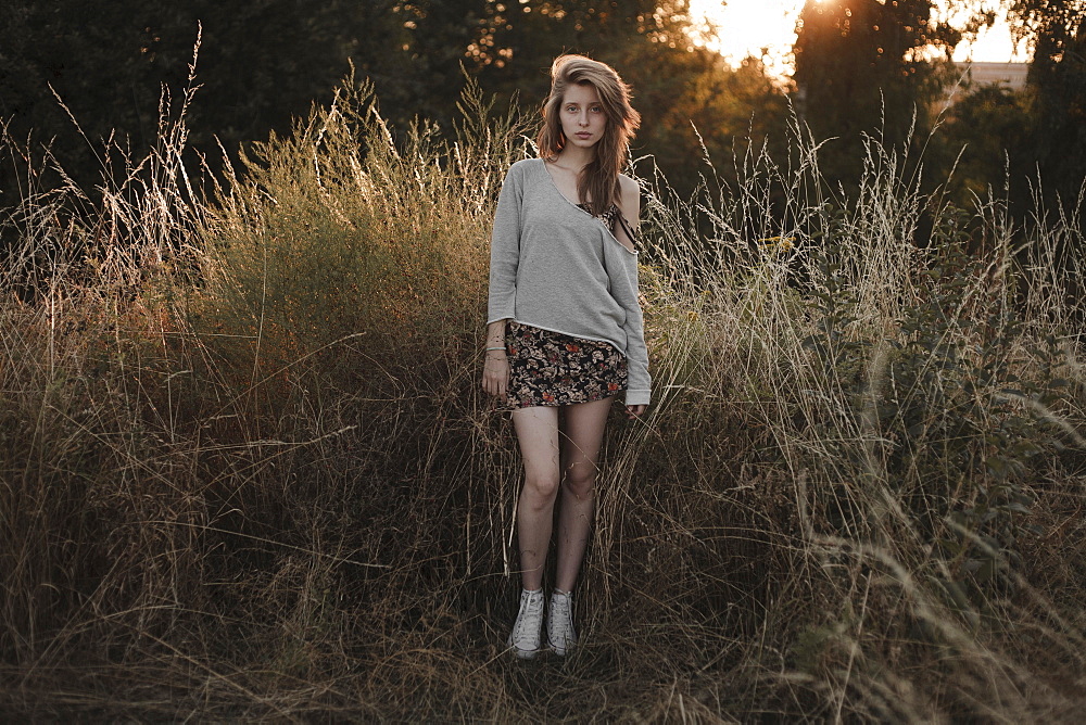 Serious Caucasian woman standing in field