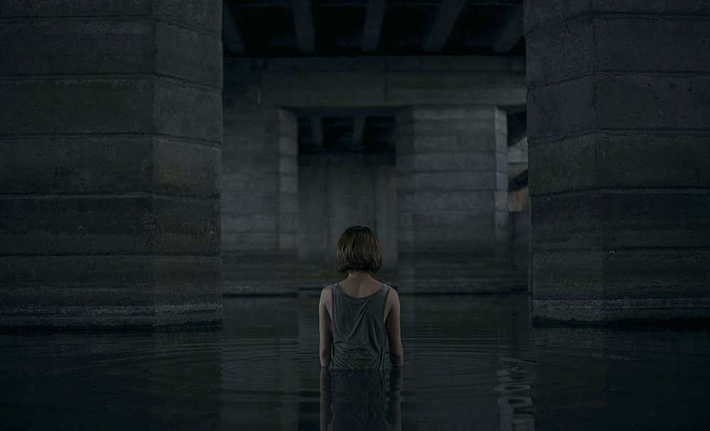 Caucasian woman standing waist deep in water