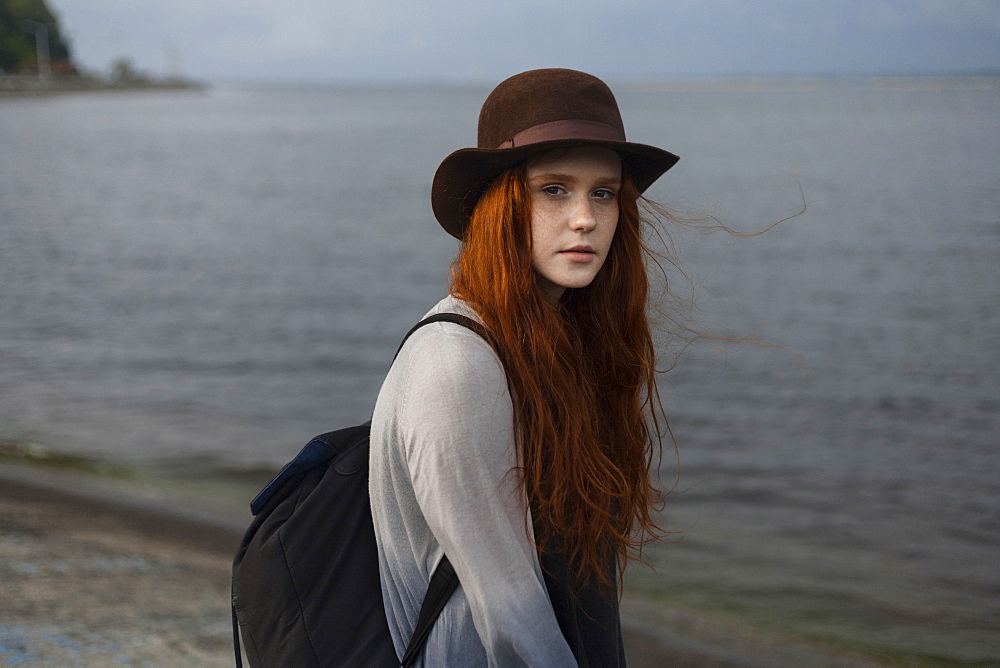 Serious Caucasian woman standing near ocean