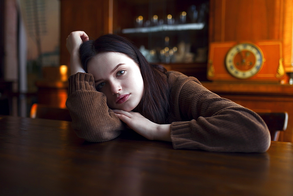 Depressed Caucasian girl leaning on table