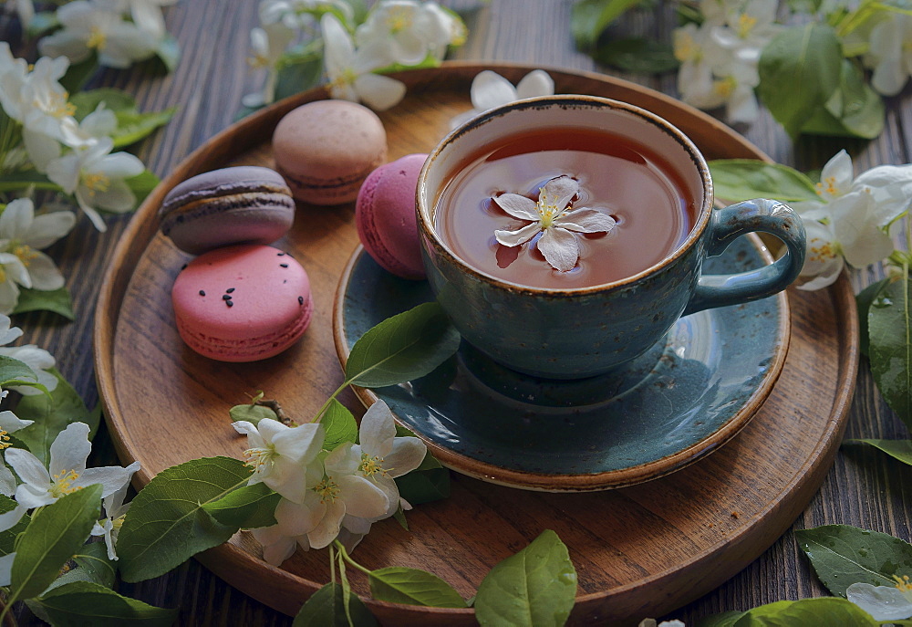 Flowers on tray with tea and macaroons