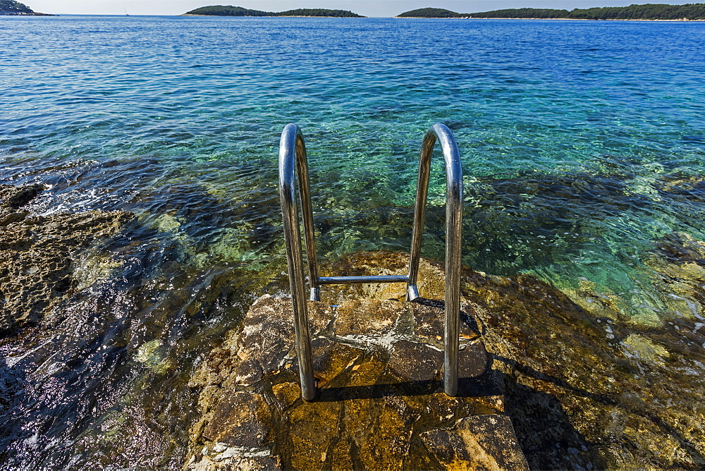 Metal railing on rocks at ocean