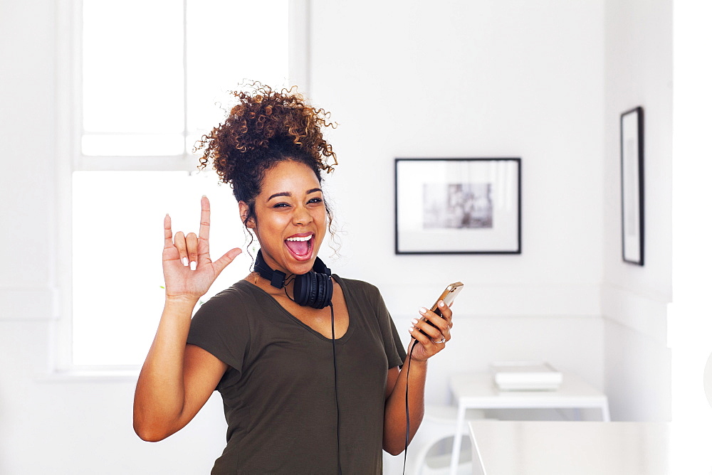 Mixed race woman gesturing and holding cell phone