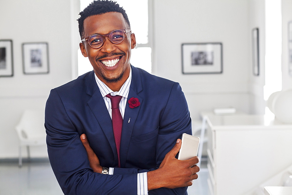 Black man with arms crossed in gallery