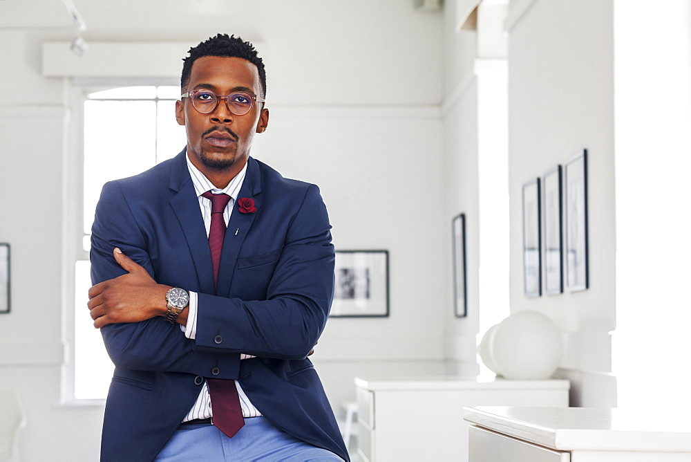 Black man with arms crossed in gallery