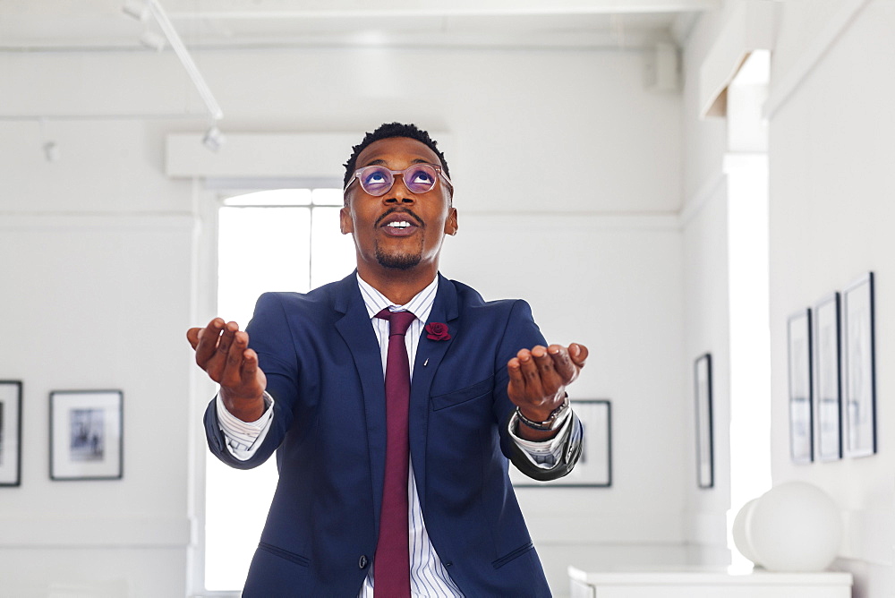 Black man gesturing and looking up in gallery