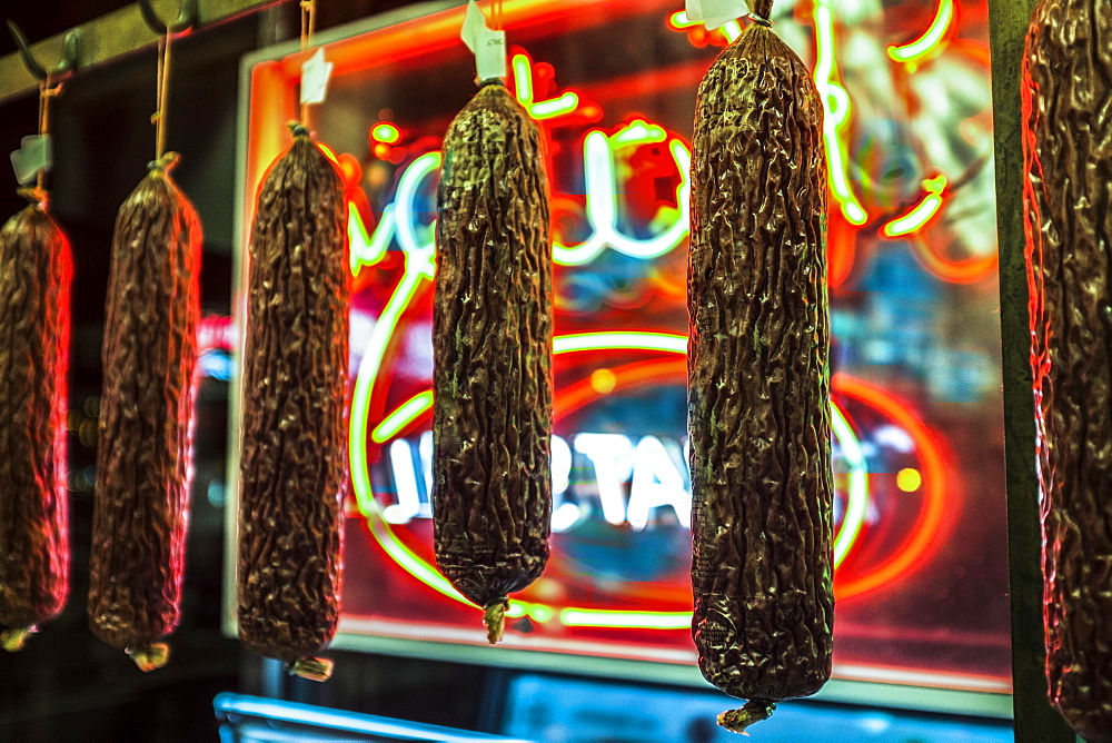 Dried meat handing near neon sign