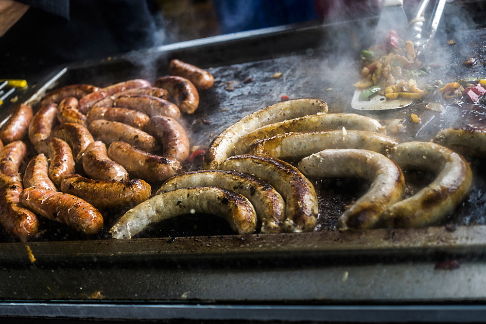 Links of meat cooking on grille