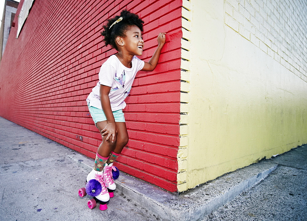 Black girl wearing roller skates peeking around corner