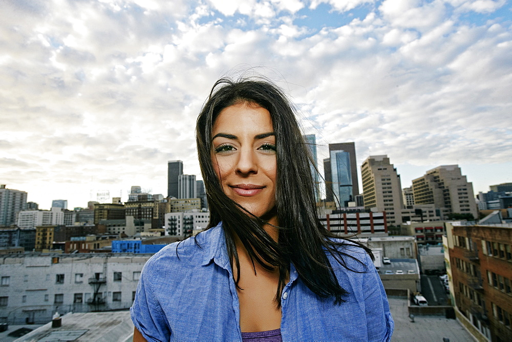 Portrait of smiling Hispanic woman on urban rooftop