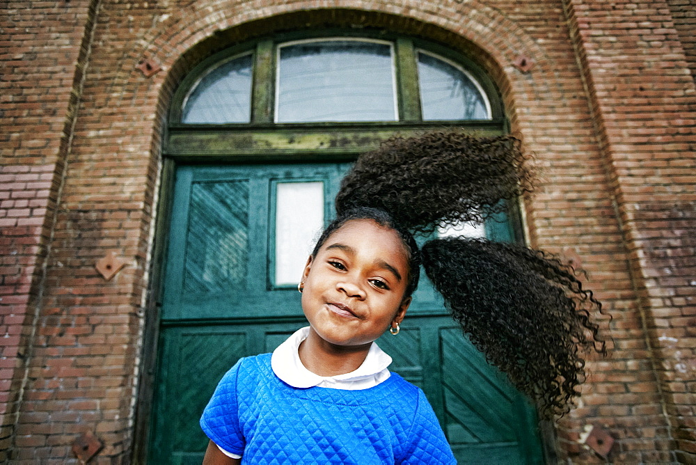 Smiling Black girl tossing hair