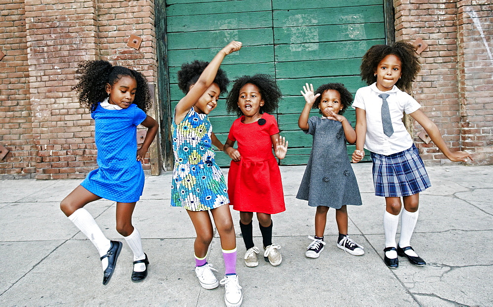 Girls dancing on city sidewalk