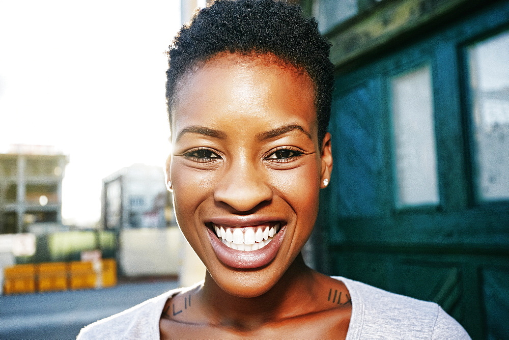 Portrait of smiling Black woman posing in city