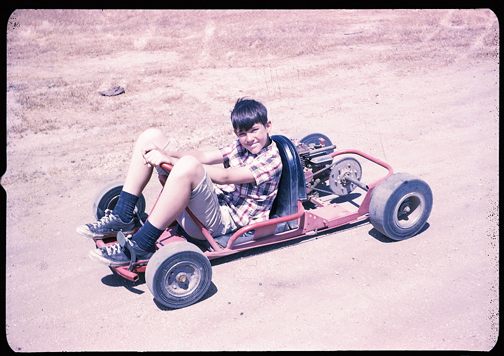 Portrait of Caucasian boy sitting on go-cart