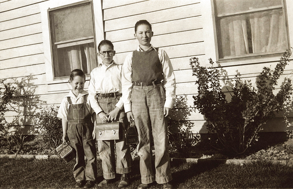 Portrait of Caucasian brothers posing near house